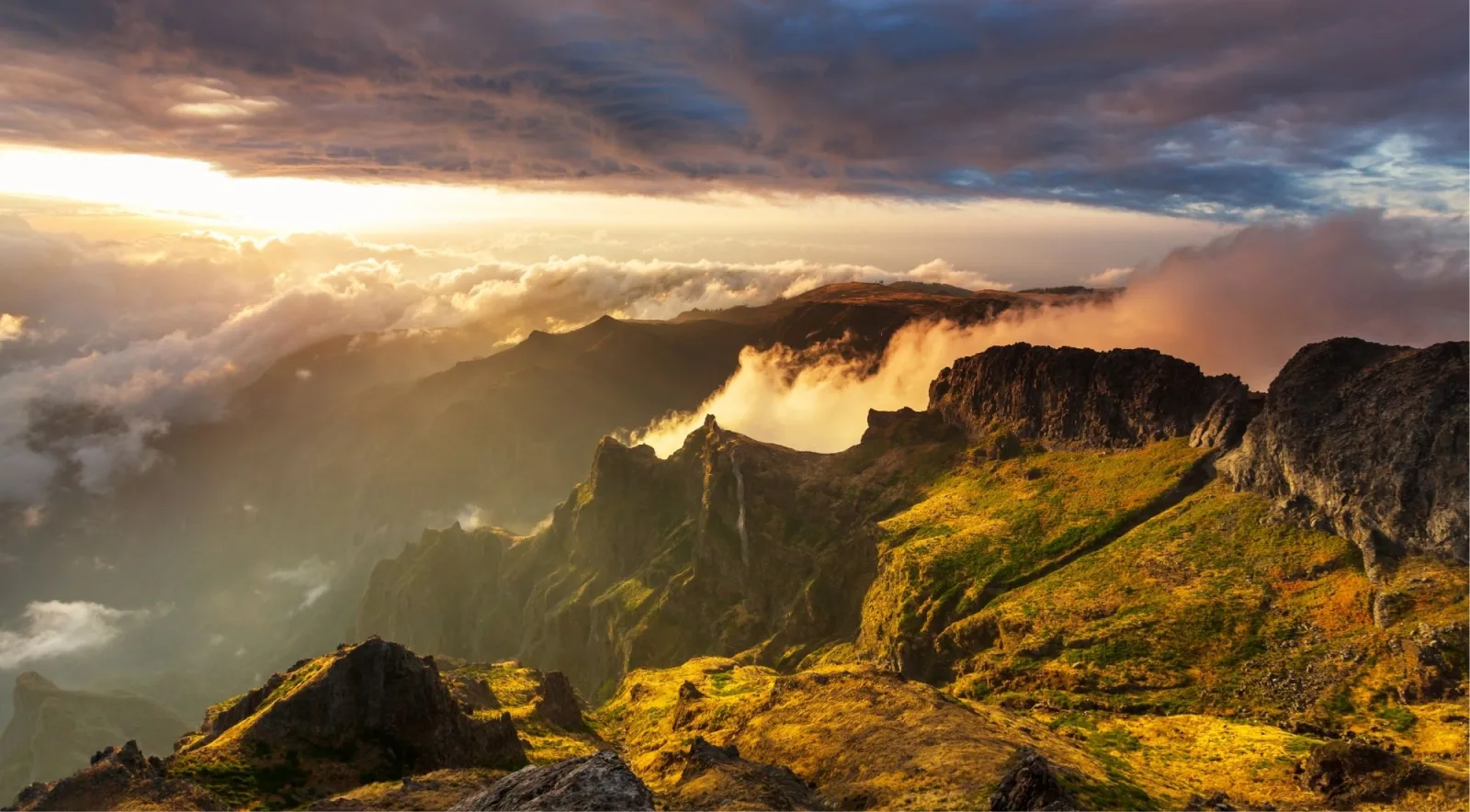 Golden evening light over the Madeira massif with a thick sea of cloud spilling between the peaks